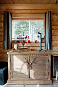 Half-height cabinet with handles made from antlers below window