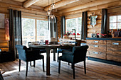 Set table and upholstered chairs in log cabin in window