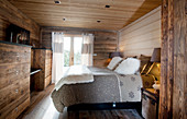 Rustic bedroom with wood panelling and log-cabin ambiance