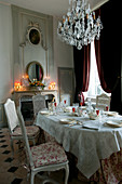 Festively set table in historical dining room with fireplace