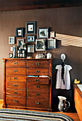 Gallery of pictures above wooden chest of drawers