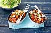 Two small casseroles with sausage, vegetables and feta