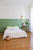 Zweifarbig gestrichene Wand im schlichten Schlafzimmer