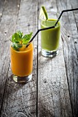 Two smoothies in glasses on a wooden table