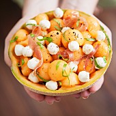 Melonensalat mit Mozzarella und Proscuitto in ausgehöhlter Melone