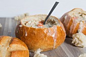 Creamy chicken soup with wild rice served in hollowed-out bread rolls