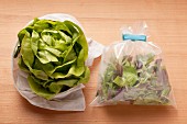 Lettuce wrapped in a damp cloth and fresh salad leaves in a plastic bag (storage)