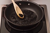 Black sesame seeds being toasted