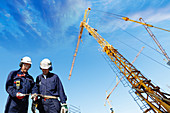 Construction workers on site with cranes