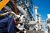 Worker checking pipework on an oil and gas refinery
