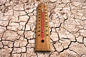 Cracked earth and thermometer