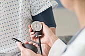 Doctor taking patient's blood pressure