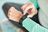 Senior woman using fitness tracker on wrist