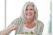 Senior woman eating salad