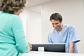 Man using computer with female patient