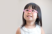 Young girl wearing pink glasses