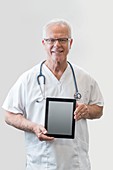 Senior male doctor holding digital tablet