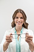 Female optician holding glasses