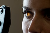 Woman having eye test with light shining in iris