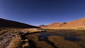 Volcano and river at sunset, time-lapse footage