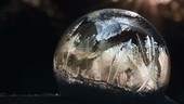 Ice crystals forming on a soap bubble