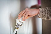 Woman adjusting a thermostatic radiator valve