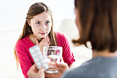 Mother giving medicine to daughter