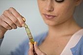 Woman holding glass ampoule of vitamin D