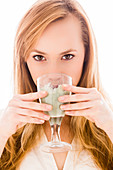 Woman drinking green clay