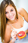 Woman eating a grapefruit