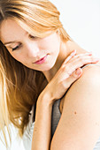 Shoulder pain, Woman rubbing her shoulder
