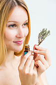 Woman smelling a bottle of thyme essential oil