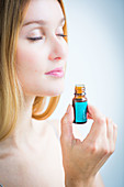 Woman smelling a bottle of essential oil