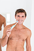 Man brushing her teeth with electric toothbrush