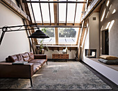 Leather couch and masonry bench in living room with skylights