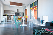 Dining table and open-plan kitchen in spacious interior