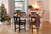 Christmas tree and festively set dining table in period apartment