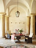 Armchairs and Advent arrangement on table below historical vaulted ceiling
