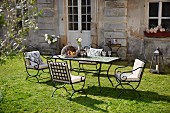Metal furniture in sunny garden outside country house