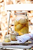 A small pear cake in a glass jar with a jar of pickled lemons