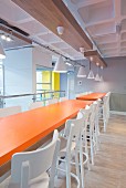 Orange tables in industrial-style canteen