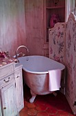 Free-standing bathtub behind floral screen
