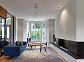 Blue sofa, fireplace and bay window in living room with minimalist furnishings