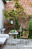 Einladender Sitzplatz auf der Terrasse vor einer Backsteinwand