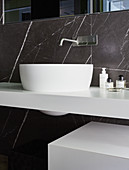 Modern sink and black marble wall in bathroom
