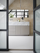 View through open glass door into modern bath with simple, clean lines