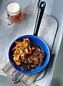 Steak with potato crisps and a glass of dark beer