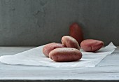 Several red-skinned potatoes on a piece of paper