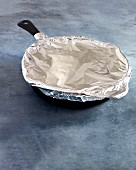 A pan covered with aluminium foil for the oven