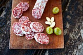 Italian salami, olives and almonds on a wooden board